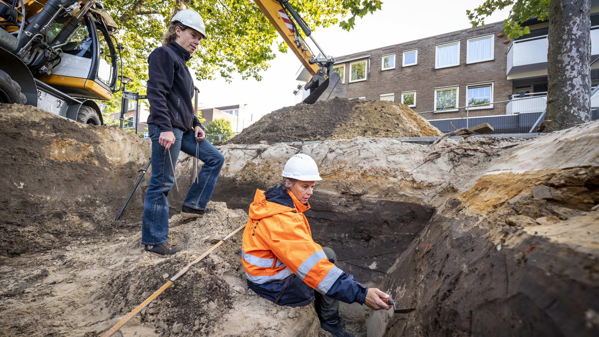 Mirjam en Juliette staan in de kuil. Zij kijken in de grond.