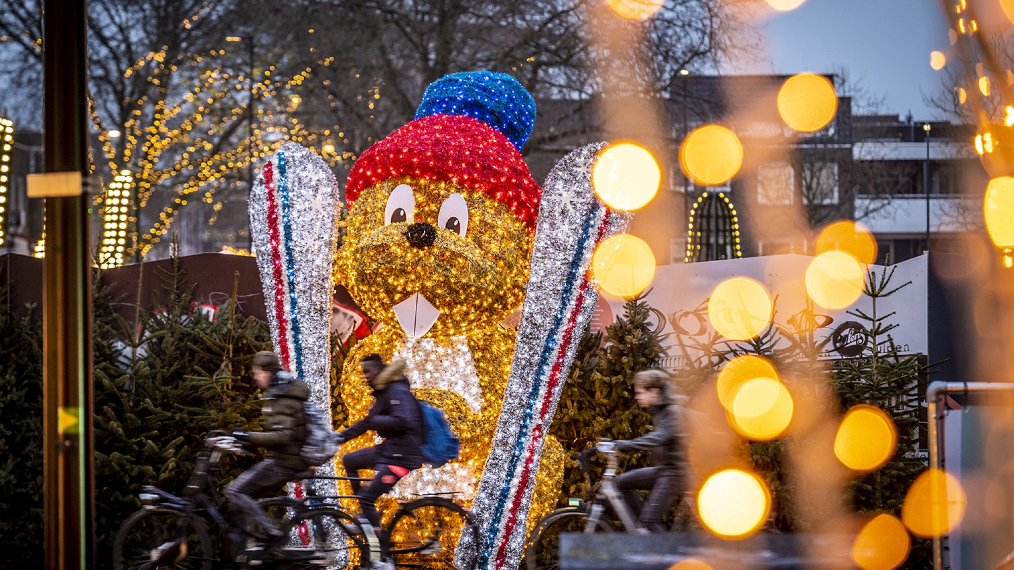 Een hamster van lichtjes met zijn ski's in de hand.