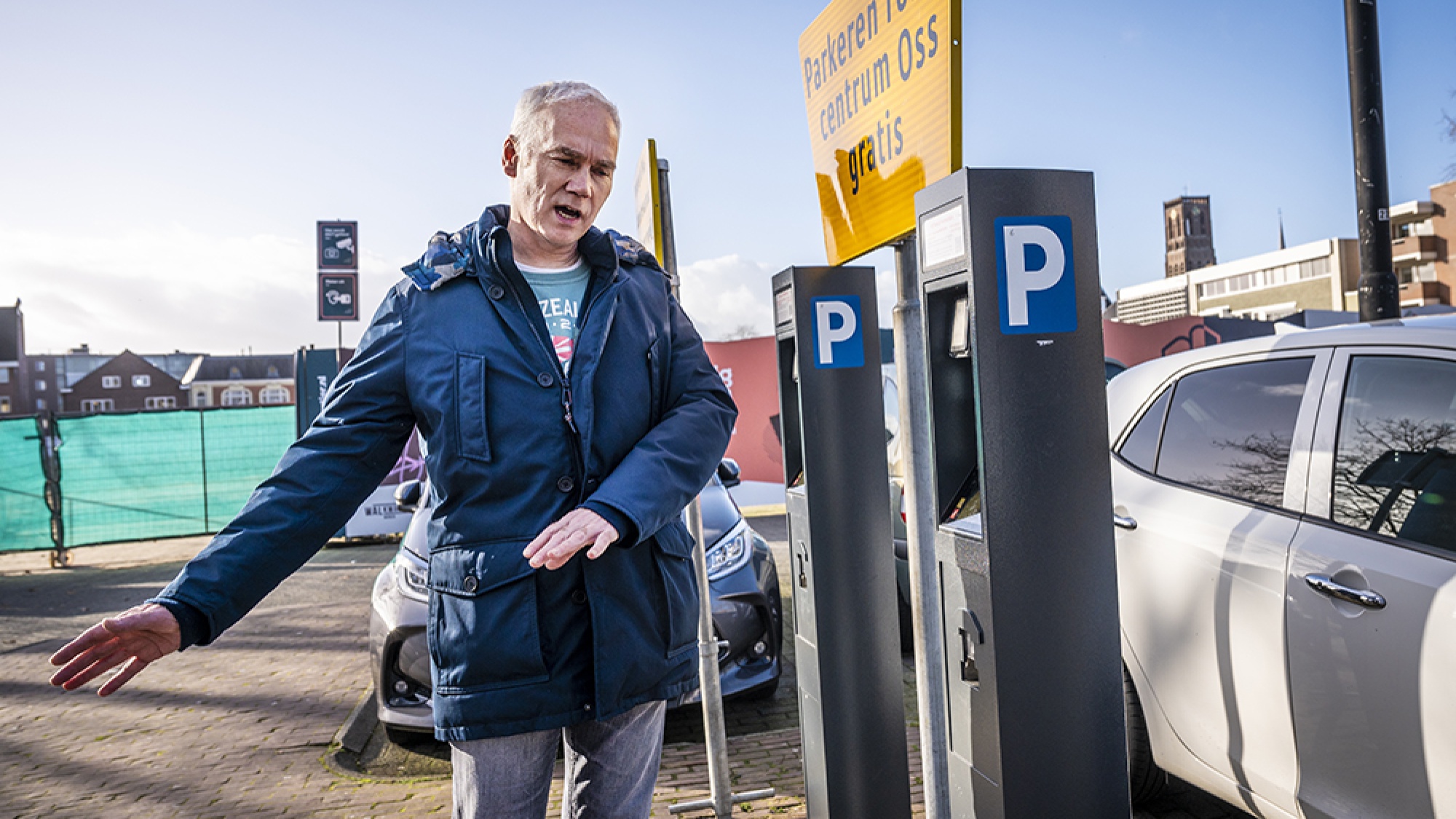 Patrick legt iets uit op de parkeerplaats 