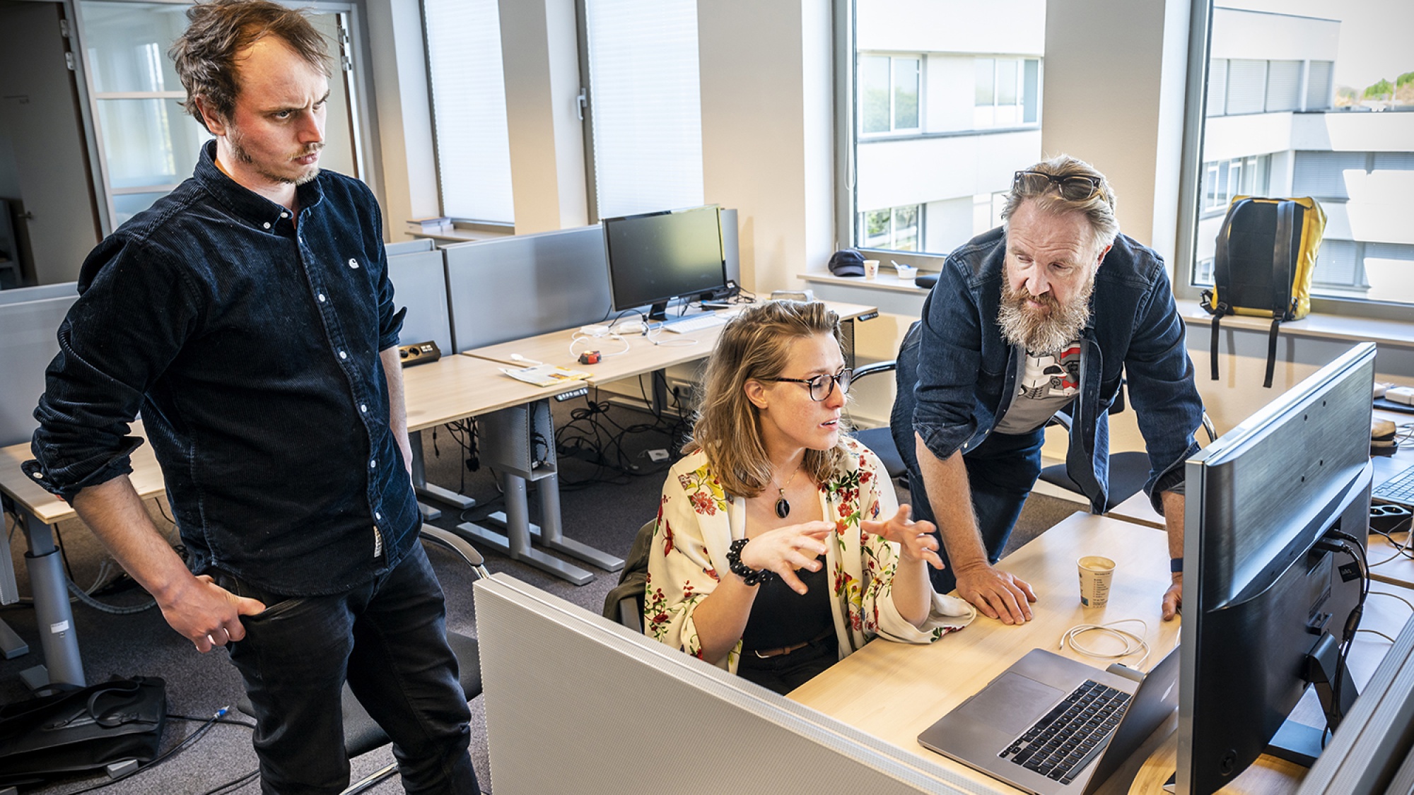 Aat, Tessa en een collega in overleg voor de computer 