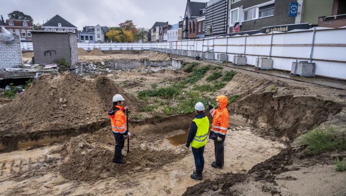 Juliette en Mirjam staan met een collega naast de gegraven kuil.