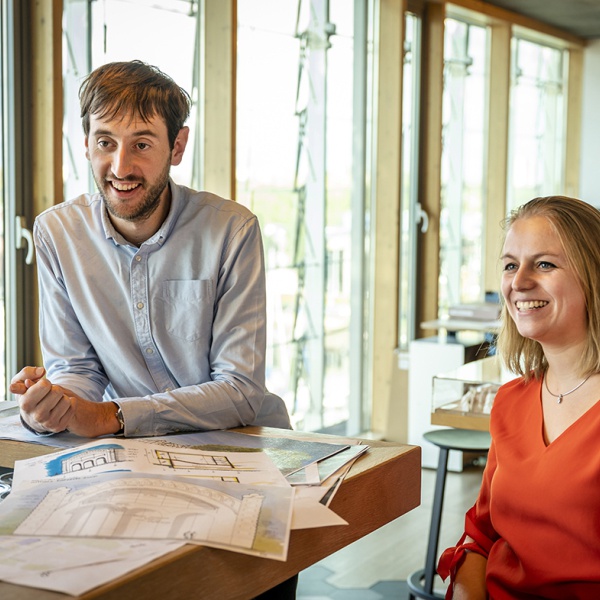 Marta en Luuk zijn samen in werkoverleg, ze lachen.