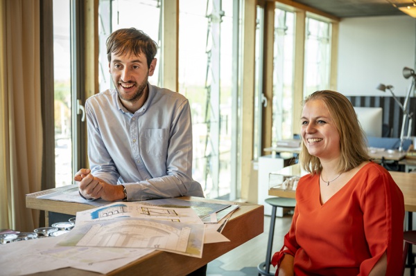 Marta en Luuk zijn samen in werkoverleg, ze lachen.