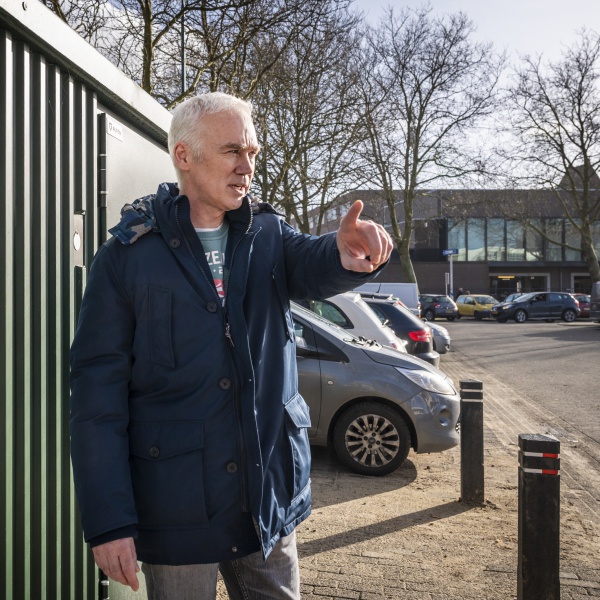 Patrick wijzend voor een container 